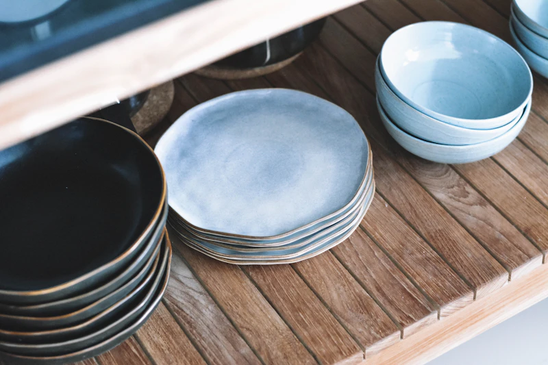 Blue ceramic plates and bowls on a wooden shelf